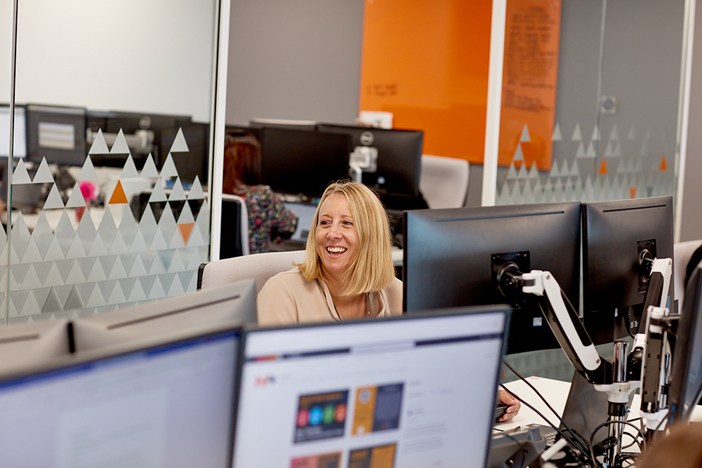 Lady sitting at a desk smiling