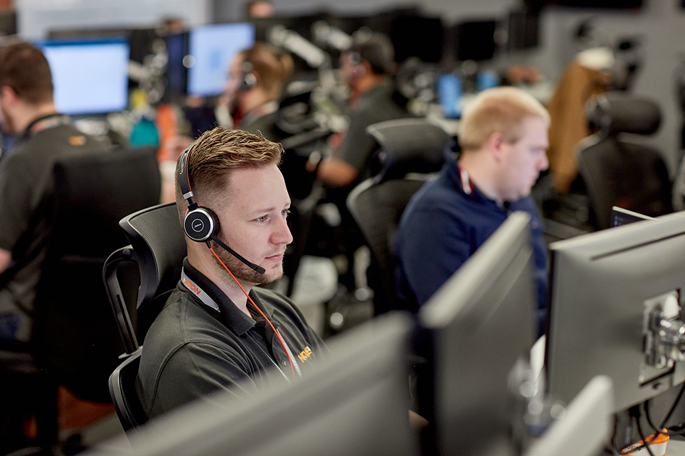 Man sitting at a computer in a support team